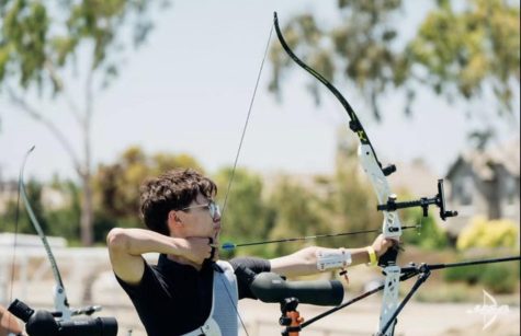 Ethan Han Holding his Bow as he prepares to shoot
